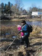  ?? COLE BURSTON FOR NATIONAL POST ?? Victoria Brighton Thorpe searches with her baby on the banks of the Grand River, in Waldemar, Ont., for signs of three-year-old Kaden Young, who was swept into the strong flood currents of the river last week.