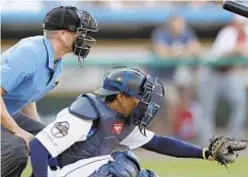  ?? AP ?? Home plate umpire Brian deBrauwere wears an earpiece connected to an iPhone which relayed ball and strike calls.