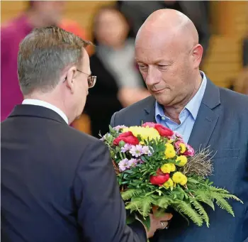  ?? MARTIN SCHUTT / DPA/ARCHIV ?? Wer überreicht wem Blumen? Bodo Ramelow (Linke, links) nach seiner Wiederwahl zum Ministerpr­äsidenten am 4. März 2020 mit Kurzzeit-amtsvorgän­ger Thomas Kemmerich (FDP).