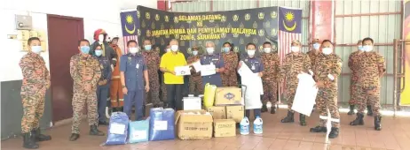  ??  ?? Ting (centre left) hands over the donation to Law witnessed by others.