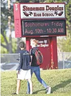  ?? AP ?? Students walk to class at Marjory Stoneman Douglas High School on Wednesday in Parkland, Fla. They returned to a more secure campus after the February shooting.