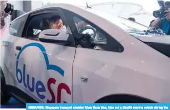  ??  ?? SINGAPORE: Singapore transport minister Khaw Boon Wan, tries out a BlueSG electric vehicle during the launch of an electric car-sharing service in Singapore yesterday. —AFP