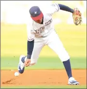  ?? NWA Democrat-Gazette/ANDY SHUPE ?? Naturals shortstop Humberto Arteaga attempts to field a grounder barehanded Wednesday against the Midland Rockhounds at Arvest Ballpark in Springdale. Visit nwadg.com/photos for more photos from the game.