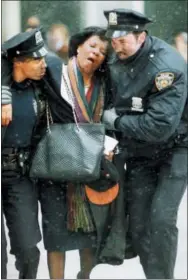  ?? JOE TABACCA— THE ASSOCIATED PRESS FILE ?? In this file photo, two New York City police officers help an injured women away from the scene of the World Trade Center truck bomb attack. It was a terror attack that foreshadow­ed Sept. 11: the deadly World Trade Center bombing that happened 25years ago Monday.