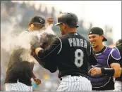  ?? JUSTIN EDMONDS — GETTY IMAGES ?? Carlos Gonzalez is doused with powder after his basesloade­d walk in the ninth inning won it for the Rockies.