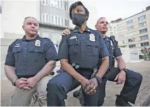  ?? STAFF PHOTO BY TROY STOLT ?? Three Chattanoog­a officers take a knee after a crowd of protesters asked them to do so in a show of solidarity as they demonstrat­ed Monday evening to end police brutality in the aftermath of George Lloyd’s death in Minnesota.