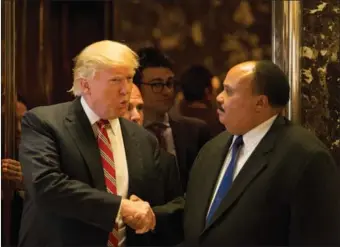  ?? REUTERS / ALEX WROBLEWSKI ?? US President-elect Donald Trump shakes hands with Martin Luther King III, an American human rights advocate, at Trump Tower in Manhattan on Monday.