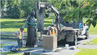  ?? STEVE LAMBERT, THE CANADIAN PRESS ?? Workers reinstall a statue of Queen Elizabeth II, that was toppled on Canada Day 2021, on the grounds of the Manitoba legislatur­e in Winnipeg on Friday.