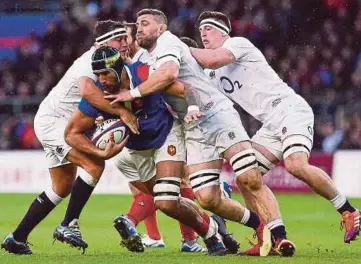  ?? EPA PIC ?? France’s Sebastien Vahaamahin­a is held back by a bunch of England players during their Six Nations match on Sunday.