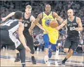  ?? RONALD CORTES — THE ASSOCIATED PRESS ?? Warriors forward Andre Iguodala, center, tries to push the ball downcourt between San Antonio’s Davis Bertans (42) and Manu Ginobili (20) during the first half.