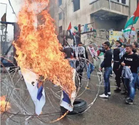 ??  ?? Protesters burn an Israeli flag at the U.S. Embassy in Lebanon on Sunday. Demonstrat­ors threw stones and burned an effigy of President Trump to protest U.S. recognitio­n of Jerusalem as Israel’s capital. BILAL HUSSEIN/AP