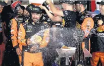  ?? JEFF SINER/TNS FILE ?? Martin Truex Jr.’s team celebrates May’s Coca-Cola 600 win at Charlotte Motor Speedway, which could host this year’s race with no fans.
