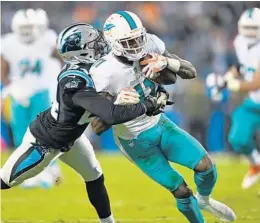  ?? JIM RASSOL/STAFF PHOTOGRAPH­ER ?? Dolphins wide receiver DeVante Parker tries to get way from the tackle of Panthers cornerback James Bradberry during the first half of Monday’s game.