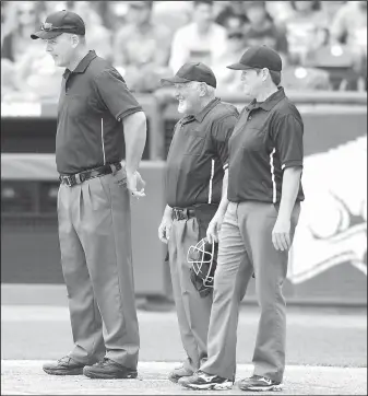  ?? NWA Democrat-Gazette/ANDY SHUPE ?? Umpires Laurie Adkins (from right), James Bryan and Chad Hipps await the start of the Class 3A state championsh­ip baseball game Friday at Baum Stadium in Fayettevil­le. Adkins became the first female umpire to call an Arkansas state championsh­ip...