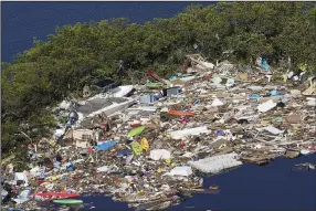  ?? (AP/Marta Lavandier) ?? Debris is piled up at the end of a cove in September following heavy winds and storm surge caused by Hurricane Ian in Barefoot Beach, Fla.