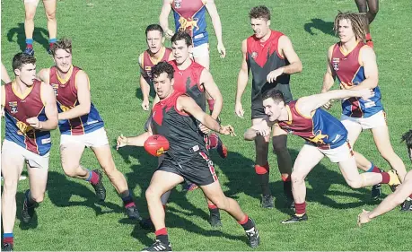  ??  ?? There were plenty of ball hunters in a tight opening quarter of the Warragul-Moe match on Saturday, Nate Paredes managing to find some space among the pack to kick Gulls into attack.. Photograph­s: Paul Cohen.