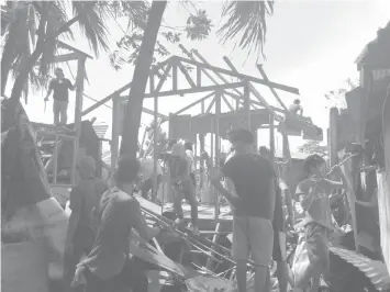 ??  ?? Members of the demolition team, hired by lot owner Ivan Go, tear down houses in Sitio Tangke, Barangay Mambaling yesterday.