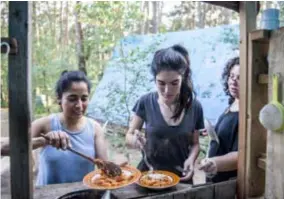  ?? FOTO KIONI PAPADOPOUL­OS ?? Yvonne, Bianca en Cande scheppen eten op: “Hier besef je pas hoe weinig je nodig hebt.”