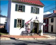  ?? The New York Times/MATT ROTH ?? Nicole Morgenthau earlier this month hangs an American flag outside her knitting shop.