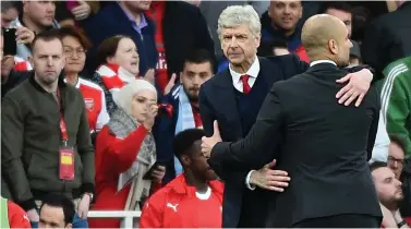  ??  ?? POINTS SHARED: Under-pressure Arsenal manager Arsene Wenger shares an embrace with Manchester City manager Pep Guardiola after yesterday’s 2-2 draw.