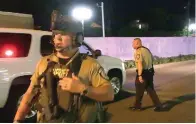  ?? The Sentinel-Record/Andrew Mobley ?? ■ A Garland County sheriff’s deputy, right, converses with another officer outside the Hot Springs Convention Center on Thursday night.