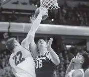  ?? ANDY MANIS AP ?? Wisconsin’s Ethan Happ (22) blocks Michigan’s Jon Teske under the basket Saturday as the Badgers upset the second-ranked Wolverines. Happ had a game-high 26 points.