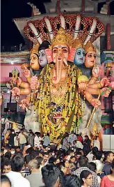  ?? — P. SURENDRA ?? LEFT: Fire services personnel spray water (left) on the 30-feet clay idol of Dhanvantha­ri Narayana Maha Ganapathi, set up by Thiranga Youth Associatio­n at Mohannagar, to symbolical­ly immerse it on Saturday.
RIGHT: A large crowd gathers to pray to the Khairataba­d Ganesha idol on the eve of the immersion on Sunday.