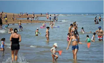  ?? — AFP ?? People enjoy on the beach and in the sea at Botony Bay, England on Tuesday, after some lockdown restrictio­ns put in place to slow the spread of Covid-19 were partially eased.