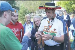  ?? STAFF PHOTO BY JOHNATHON CLINKSCALE­S ?? Mike Callahan, an educator and naturalist from the Nanjemoy Creek Environmen­tal Education Center, shows people how to tag a monarch butterfly during one of three tag and release sessions on Saturday outside of the Cobb Island Volunteer Fire Department.