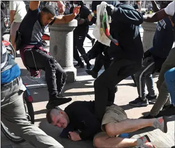  ??  ?? NO MERCY: One man is kicked while he is on the ground during the violence in Trafalgar Square