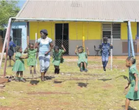  ??  ?? A caregiver and her charges at the infant department of the Woodlands Primary and Infant School