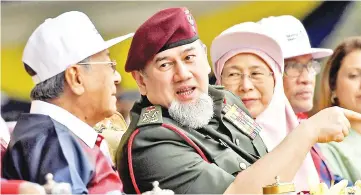  ?? - Bernama photo ?? Yang di-Pertuan Agong Sultan Muhammad V (second, left) speaking to Prime Minister Tun Dr Mahathir Mohamad (left) while watching the 61st National Day celebratio­n at Dataran Putrajaya yesterday.