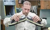  ?? GUS POWELL/THE NEW YORK TIMES ?? Artisan Alessandro Pastore compares the soles of a pair of sneakers June 7 during a repair at the Golden Goose flagship store in Milan.