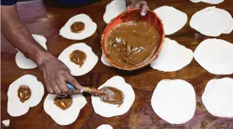  ??  ?? Genaro Solis fills coyotas with jamoncillo, made with milk and sugar, at Coyotas Doña Maria in Hermosillo. Solis makes about 1,500 coyotas daily.