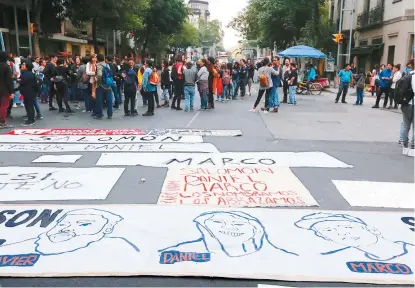  ??  ?? Manifestan­tes en CdMx el martes extendiero­n una manta con la imagen de los alumnos asesinados.