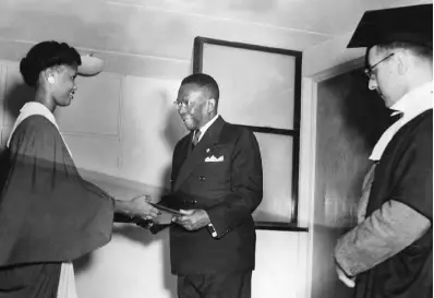  ?? GLEANER PHOTO ?? Sybil Campbell (left), a Jamaican undergradu­ate at the University College of the West Indies, presenting an album of photograph­s to President Tubman on behalf of the Guild of Undergradu­ates at the University College library. At right is Professor A.K. Croston, acting principal of the college.