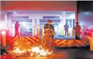  ?? AP PHOTO/NOAH BERGER ?? A Department of Homeland Security officer emerges from the Mark O. Hatfield United States Courthouse after demonstrat­ors lit a fire on Sunday in Portland, Ore.