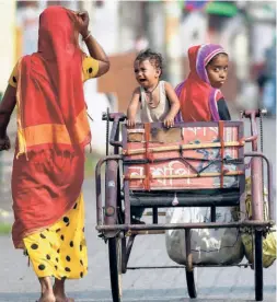  ??  ?? IN GUWAHATI on April 22, during the lockdown, a physically challenged woman and her son, accompanie­d by a relative, in search of a free food distributi­on centre.