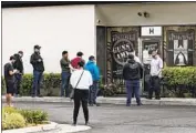  ?? Gina Ferazzi Los Angeles Times ?? CUSTOMERS wait in line to buy guns at Warrior One Guns & Ammo in Riverside on Tuesday.