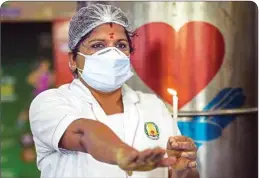  ?? PTI ?? A nurse at Rajiv Gandhi Government General Hospital lights candle and takes oath during an event to mark the Internatio­nal Nurses Day, amid COVID-19 lockdown in Chennai, on Tuesday