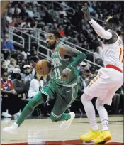  ?? John Bazemore ?? The Associated Press Celtics guard Kyrie Irving drives past Hawks guard Dennis Schroder in the first half of Boston’s 110-107 victory Monday at Philips Arena.