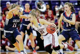  ?? [AP PHOTO] ?? Oklahoma’s Gabbi Ortiz (21) drives past Gonzaga defenders Laura Stockton (11) and Emma Stach during the second half of a first-round game in the NCAA women’s college basketball tournament in Seattle.