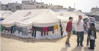  ?? ?? Heba al-Haddad (R) and her family, displaced from Gaza City, stand in a makeshift tent camp, Rafah, Gaza, Palestine, March 29, 2024.