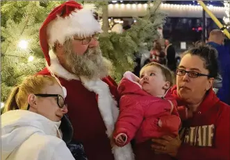  ?? BILL LACKEY / STAFF ?? Santa Clause poses for pictures in front of the Springfiel­d holiday tree last Friday during the city’s Grand Illuminati­on celebratio­n.