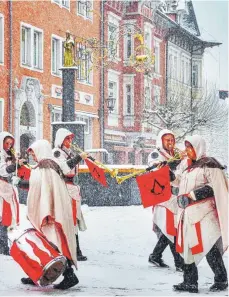  ?? FOTO: HEINZ BUCHER ?? Die Isnyer Reichsstad­t-Fanfaren gestern im dichten Schneetrei­ben am Schmalzbru­nnen beim Gang durch die Wassertors­traße.