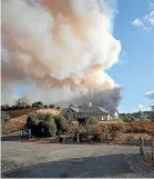  ??  ?? Guy Mollett photograph­s his Redwood Valley home as his family evacuated during the forest fire.