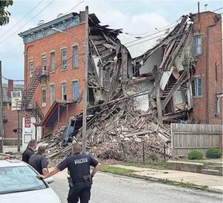  ?? DORAL CHENOWETH/COLUMBUS DISPATCH ?? Columbus firefighte­rs were on the scene just before noon Monday when a smaller collapse of the back half of 1032 E. Long St. suddenly gave way.