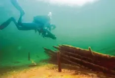  ?? Foto: dpa ?? Ein Forschungs­taucher taucht im trüben Wasser des Bodensees und untersucht dort ein Schiffswra­ck.