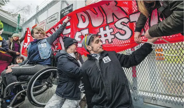  ??  ?? Protesters attach themselves to the gate in front of the Kinder Morgan Trans Mountain Pipeline facility on Burnaby Mountain Tuesday before being arrested. The number of people in violation of an injunction granted to the company March 15 reached 55.