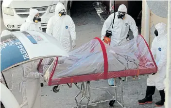  ?? Picture: REUTERS/JOSE LUIS GONZALEZ ?? TAKING PRECAUTION­S: Funeral workers remove the body of a coronaviru­s disease (Covid-19) victim from a hearse at a funeral parlour, in Mexico